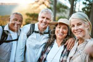 Hiking team taking a selfie in the natural woods, mountains and forest outdoors together in nature. Healthy, happy and senior couples outside on holiday to keep active, friendship and fit on a hike