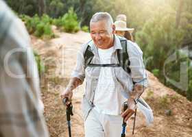 Hike, trekking sticks and senior male walking with friends for fitness and health in nature. Healthy, active and smiling mature man hiking with a backpack. Old group on an outdoor wellness adventure
