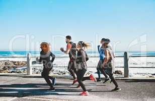 Friends offer encouragement to keep you going. a fitness group out running on the promenade.
