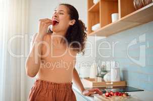 Eating, chopping or making fruit salad with strawberries, bananas or healthy ingredients in home kitchen. Smiling or happy woman cooking, biting and tasting fresh snack food or preparing breakfast