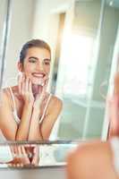 Oh so fabulous skin is simply the best. an attractive young woman inspecting her skin in the mirror.