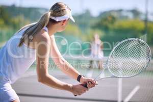 Active female tennis player back in motion holding racket, playing game match on outdoor sports court. Professional athlete training for sporty summer fun or fitness, health and wellness lifestyle.
