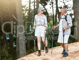 Hiking, adventure and exploring with a senior couple or friends having fun, exercising and enjoying the outdoors. Walking, discovering and journey with old people talking in nature, forest or woods