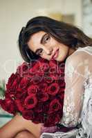 Roses makes everyones life more romantic. Portrait of a beautiful young woman holding and resting with her face on a bouquet of roses that she bought.
