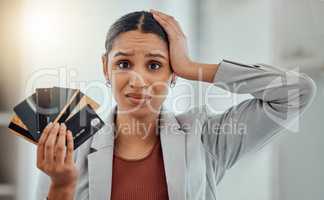 Stressed, worried businesswoman in debt from shopping at work. Female in corporate finance, money issues headache, holds credit and debit cards. Frustration, economic inflation and expenses.