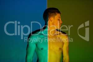 Which side are you on. Studio shot of a young man posing against abstract lighting.