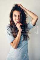 Theres nothing weird about being weird. Studio shot of an attractive young woman posing with her hand in her hair.