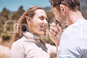 In love, romance and smiling young couple bonding on sunny summer holiday or spring vacation. Hand kissing, cheerful and trendy romantic dating and relationship partners together on getaway trip.