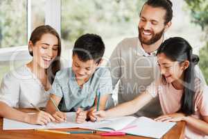 Learning, education and homework with a family writing, drawing and studying together on a table at home. Parents and children bonding and spending time together while feeling happy and carefree