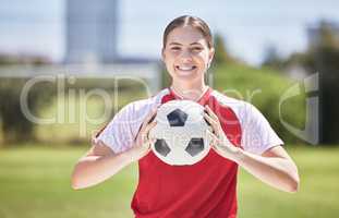 Soccer player, ball and young woman happy to play a fun sports game in a practice stadium field in summer. Exercise, training and workout of a healthy, fitness and athlete smiling on a grass pitch