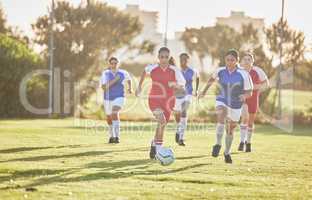 Female football, sports and team playing match on a field while passing, touching and running with a ball. Active, fast and skilled soccer players in a competitive game on a pitch outdoors.