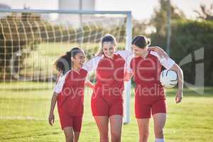 Fun female football players or friends in sportswear hugging, smiling and bonding together after practicing on a field. Young, sport and athletic soccer girls talking about good and exciting match