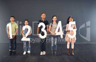 Learning is as easy as 1,2,3. Studio portrait of a diverse group of kids holding up numbers against a gray background.