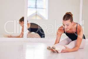 Ballet dancer, ballerina and artist stretching and preparing to dance beautiful, elegant or classical choreography. Professional studio performer and dancer helping flexibility in legs for rehearsal