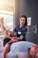 How does that feel. a young female physiotherapist treating a mature male patient.