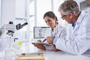 This could be the next big significant development in science. two scientists working together on a digital tablet in a lab.