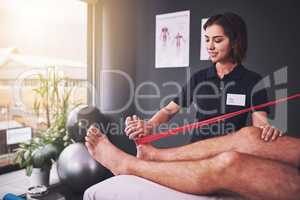 Youre making excellent progress. an attractive young female physiotherapist treating a male patient.
