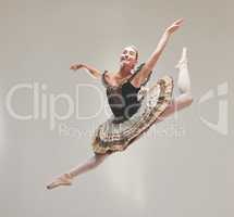 Elegant ballet dancer dancing with a vintage style, jumping and performing in a studio. Portrait of a skilled, talented and young ballerina leaping high in the air enjoying her performance