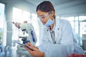 Technology helps facilitate scientific breakthroughs. a female scientist using a digital tablet in a lab.