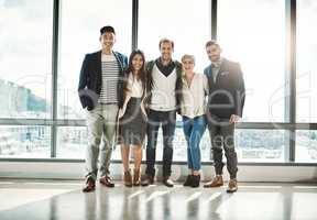 Together they make a unbeatable team. Portrait of a group of confident businesspeople standing together in the office during the day.