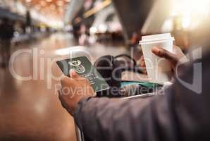 Waiting for the boarding call. POV shot of an unrecognizable man holding his passport and boarding pass while enjoying a coffee in the airport.