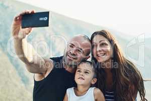 And now for a family selfie. a family of three taking a selfie together.