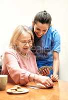 Youre better than you thought. a female nurse teaching her patient how to play a card game.