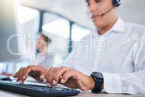 Call center agent hands or CRM consultant typing client information on PC keyboard while talking on phone with headset. Contact us for customer service or telemarketing hotline support assistance.
