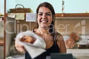 Freshly made just for you. a young woman working in her bakery.