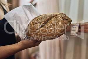 Baked to perfection. an unrecognizable woman holding freshly baked bread.