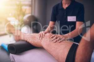 Checking on his knee. an unrecognizable female physiotherapist treating a male patient.