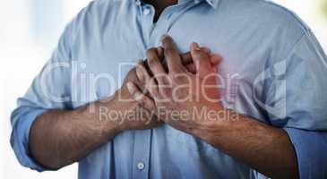 Chest pain is an indicator of a possible heart attack. Closeup shot of an unidentifiable businessman suffering with chest pain at work.