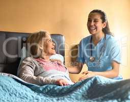 Her positivity is contagious. a female nurse chatting to her senior patient.