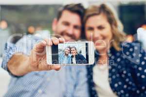 Because I want to capture every moment with you. an attractive couple taking a picture with a cellphone at home.