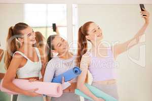 Yoga, fitness and phone selfie with a group of healthy and active women training and taking pictures in gym or exercise class. Health, wellness and lifestyle with a team of girls after a workout