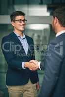 Its important to continually make new business contacts. two businessmen shaking hands in an office.