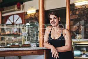 We sell thee best baked goods in town. a young woman working in her bakery.