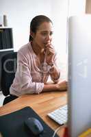 I really hope Ill be able to meet all these deadlines. a young businesswoman biting her nails while working on a computer in an office.