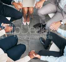 Support, teamwork and unity of business group holding hands and sitting in a circle doing a team building plan. People, team or diverse employees united in trust during a meeting in an office