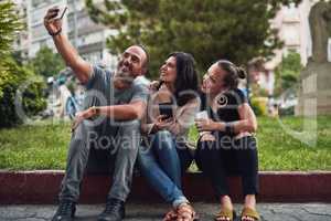 I need to feed my social media accounts. three friends taking a selfie while enjoying themselves out in the city.