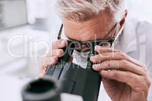 Science is a way to investigate, improve and correct phenomena. a mature scientist using a microscope in a lab.