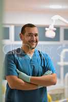 He will see to it that you have a bright smile everyday. Portrait of a cheerful young male dentist standing with his arms folded while looking at the camera in his office.