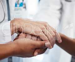 Doctor, holding a patients hands and comforting them after the loss of a loved one at a hospital. Medical consultant, reassuring sick person after a cancer diagnosis and giving support or treatment.