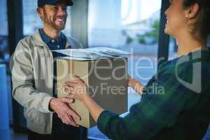 Its a delight to deliver to your door. a delivery man making a delivery to a customer at her home.