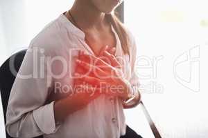 Stress is a high factor in causing chest pain. Closeup shot of an unidentifiable businesswoman holding her chest in pain.