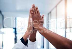 High five, success and doctors celebrating teamwork, medical collaboration and support in a hospital. Closeup of healthcare hands joining in a huddle for winning achievement, motivation and victory