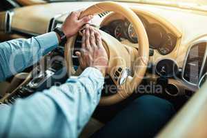 Hes getting impatient with all this traffic. Closeup shot of an unrecognisable businessman pressing the hooter on a steering wheel of a car.