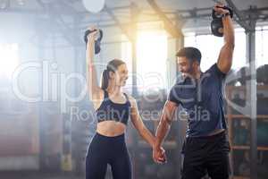 Fitness, kettlebell and couple in a workout exercise and holding hands in a gym. Fit sports people in a relationship with a strong grip, exercising with weight equipment to build muscle together.