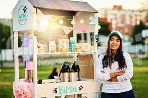 We are the freshest in town. a cheerful young woman standing next to her baked goods stall while looking at the camera.
