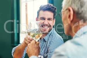 Heres to many more times like these together. a cheerful young man and his mature father sharing a celebratory toast with wine glasses at home.